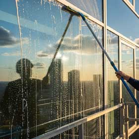 Eingeschäumtes Schaufenster wird mit Wischgummi abgezogen