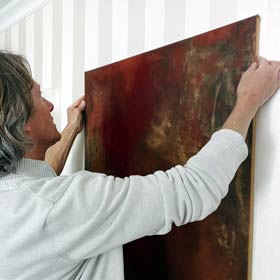 Michael beim Aufhängen eines Gemäldes