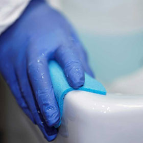 Putzeimer mit schäumendem Lappen, der ausgewrungen wird